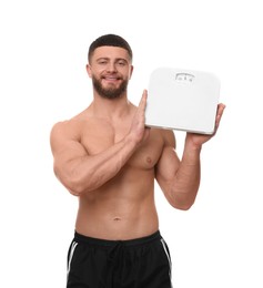 Photo of Portrait of happy athletic man with scales on white background. Weight loss concept