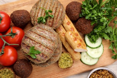 Photo of Different tasty vegan meat products and fresh vegetables on wooden table, flat lay