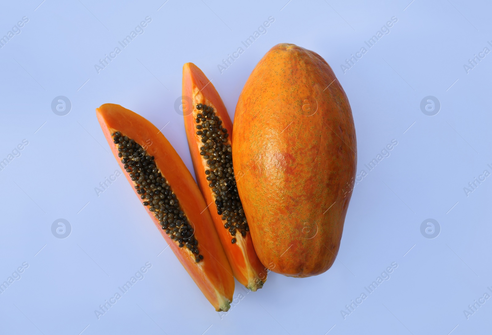 Photo of Fresh juicy cut and whole papaya fruits on white background, flat lay