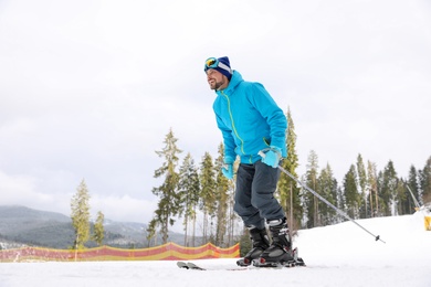 Photo of Male skier on slope at resort, space for text. Winter vacation