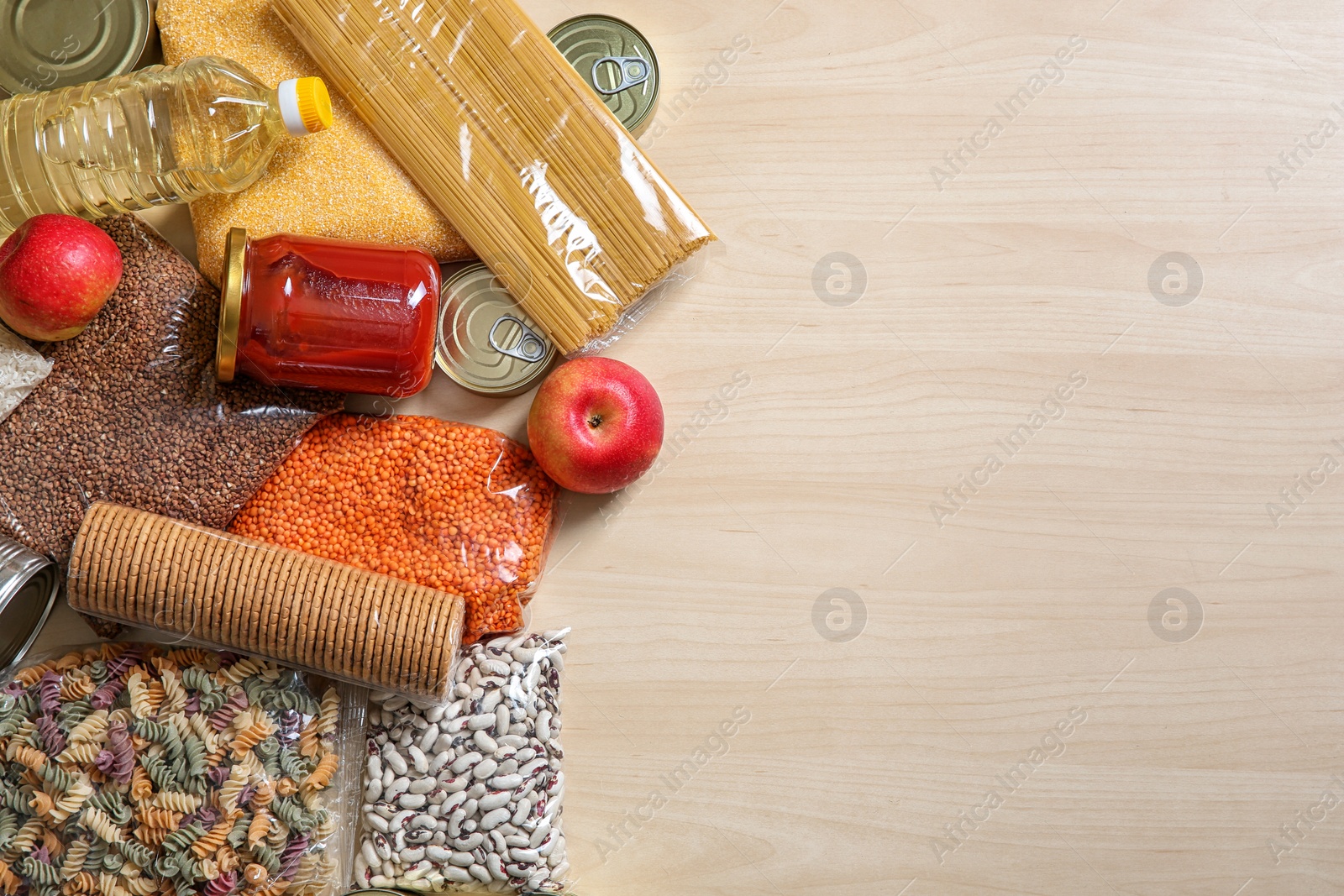 Photo of Many different products and space for text on wooden background, flat lay. Food donation