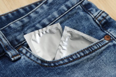 Photo of Packaged condoms in jeans pocket, closeup. Safe sex