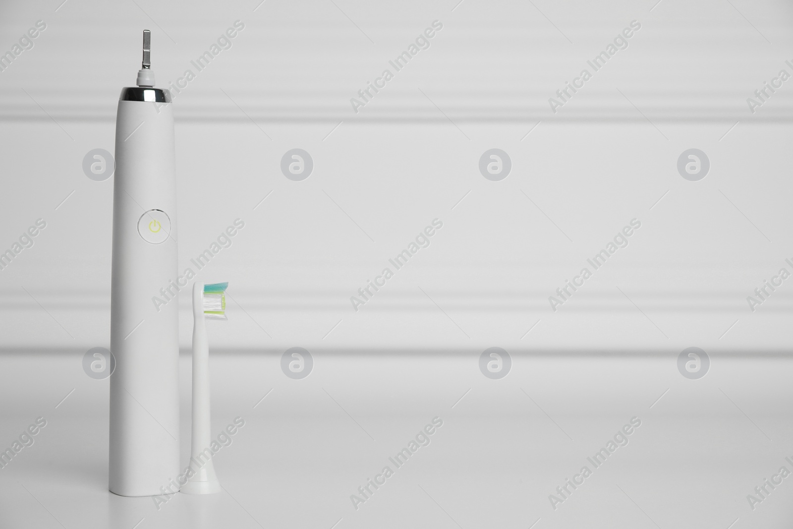 Photo of Electric toothbrush on white background, space for text