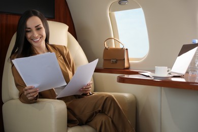 Photo of Businesswoman working with documents in airplane during flight