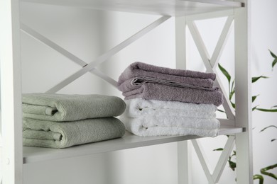 Photo of Stacks of soft towels on shelf indoors