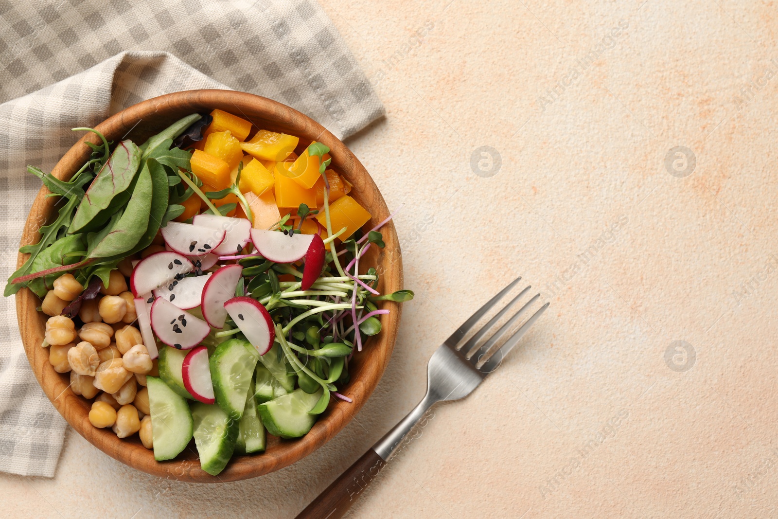 Photo of Delicious vegan bowl with cucumbers, chickpeas and radish on beige table, flat lay. Space for text