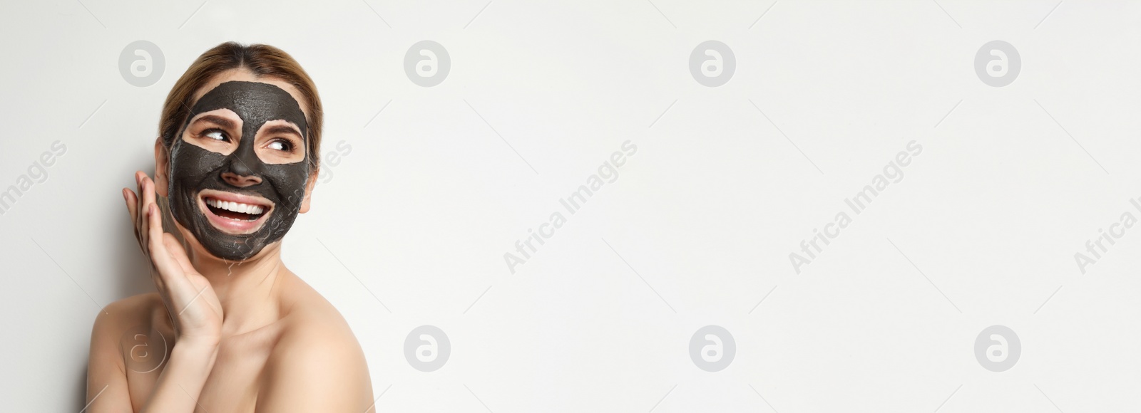 Image of Beautiful woman with black mask on face against light background, space for text. Banner design