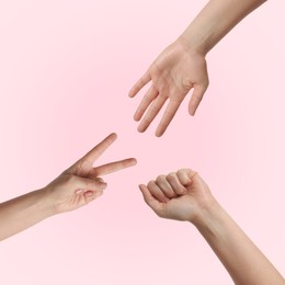 People playing rock, paper and scissors on pink background, top view