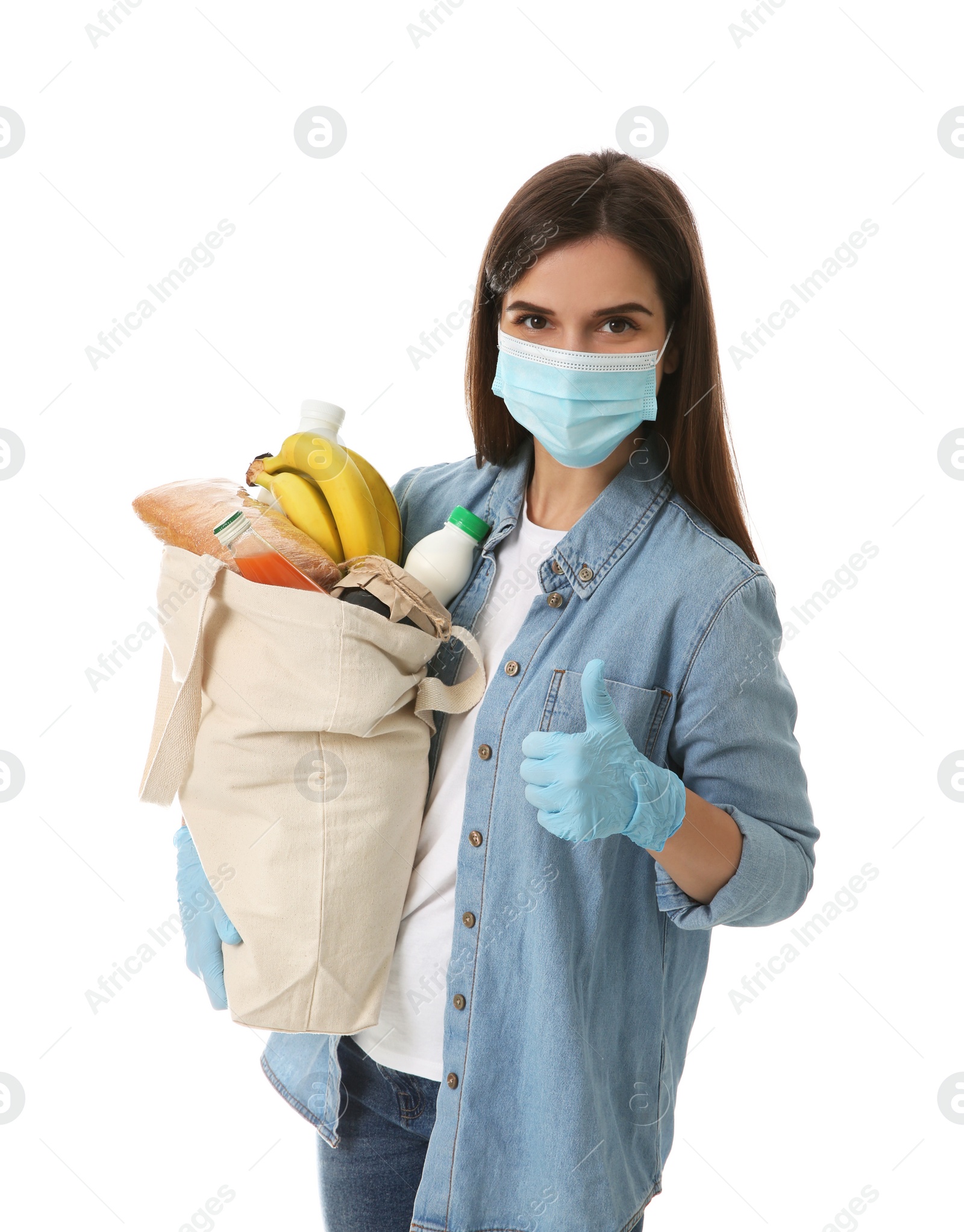 Photo of Female volunteer in protective mask and gloves with products on white background. Aid during coronavirus quarantine