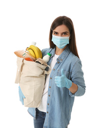 Female volunteer in protective mask and gloves with products on white background. Aid during coronavirus quarantine