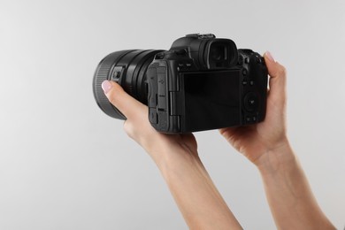 Photo of Photographer with camera on light grey background, closeup