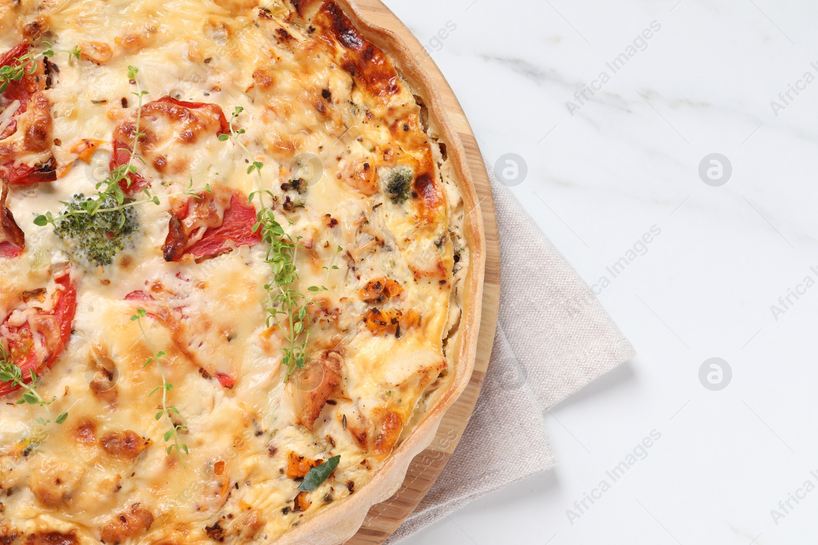 Photo of Tasty quiche with tomatoes, microgreens and cheese on white table, top view. Space for text