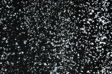 Photo of White snow falling down on black background