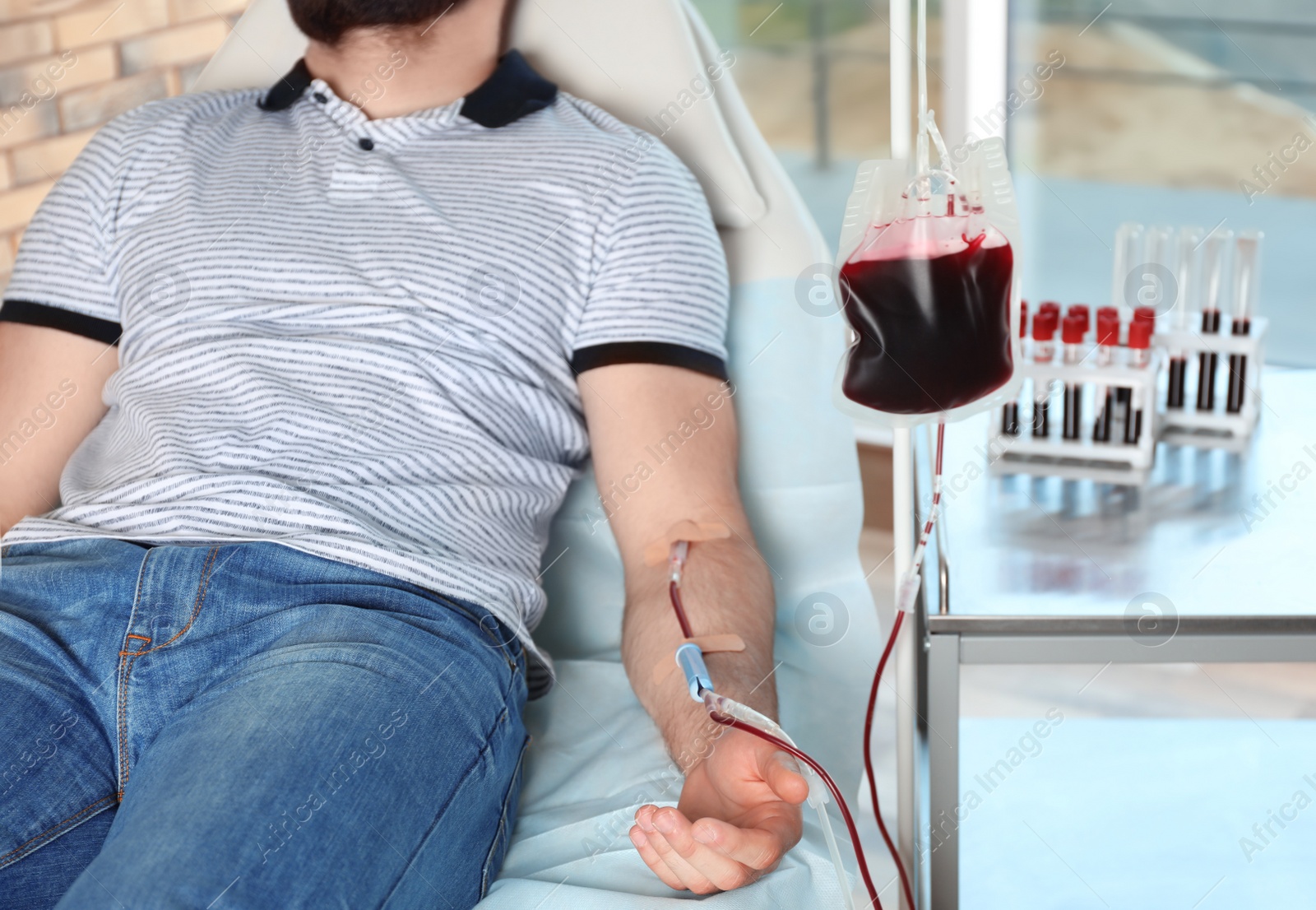 Photo of Man making blood donation at hospital, closeup