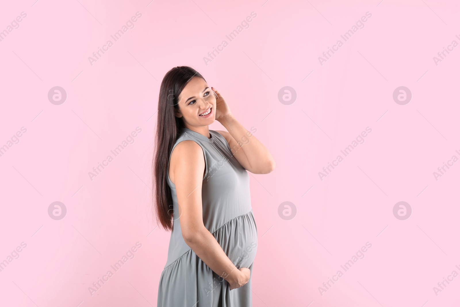 Photo of Young beautiful pregnant woman against color background. Space for text