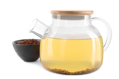 Glass teapot with aromatic buckwheat tea and granules on white background