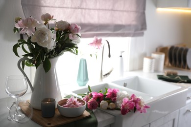 Photo of Beautiful kitchen counter design with fresh peonies