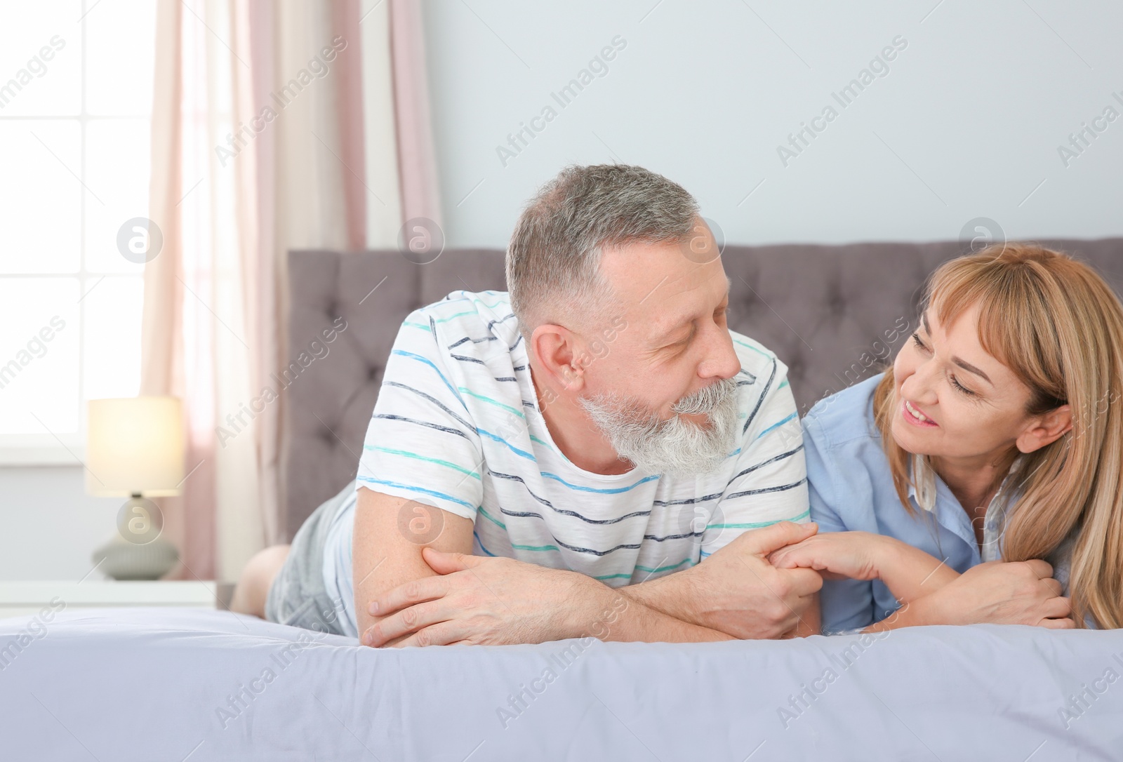 Photo of Mature couple together on bed at home