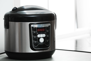 Photo of Modern electric multi cooker on table. Space for text
