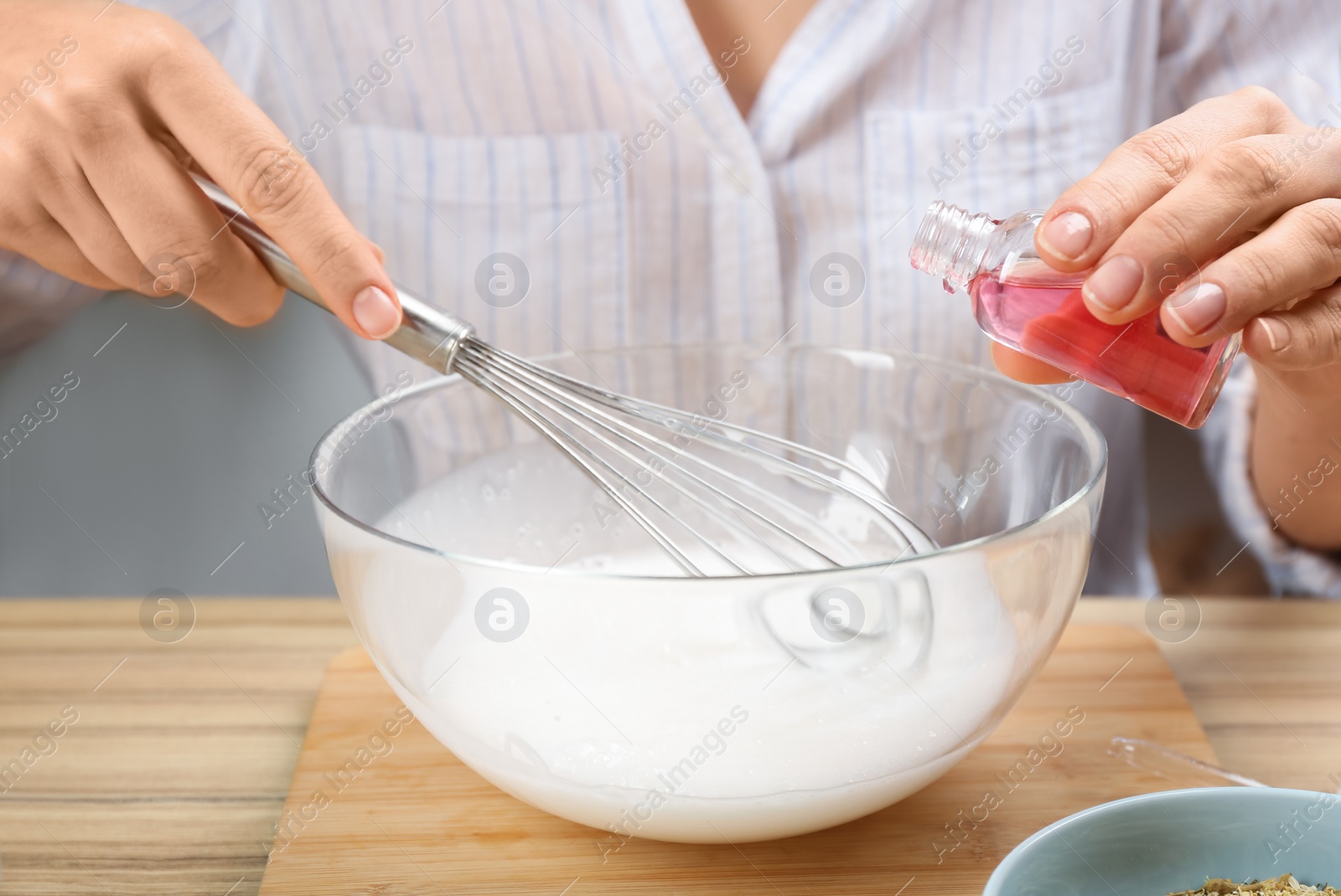 Photo of Woman making natural handmade soap at wooden table, closeup