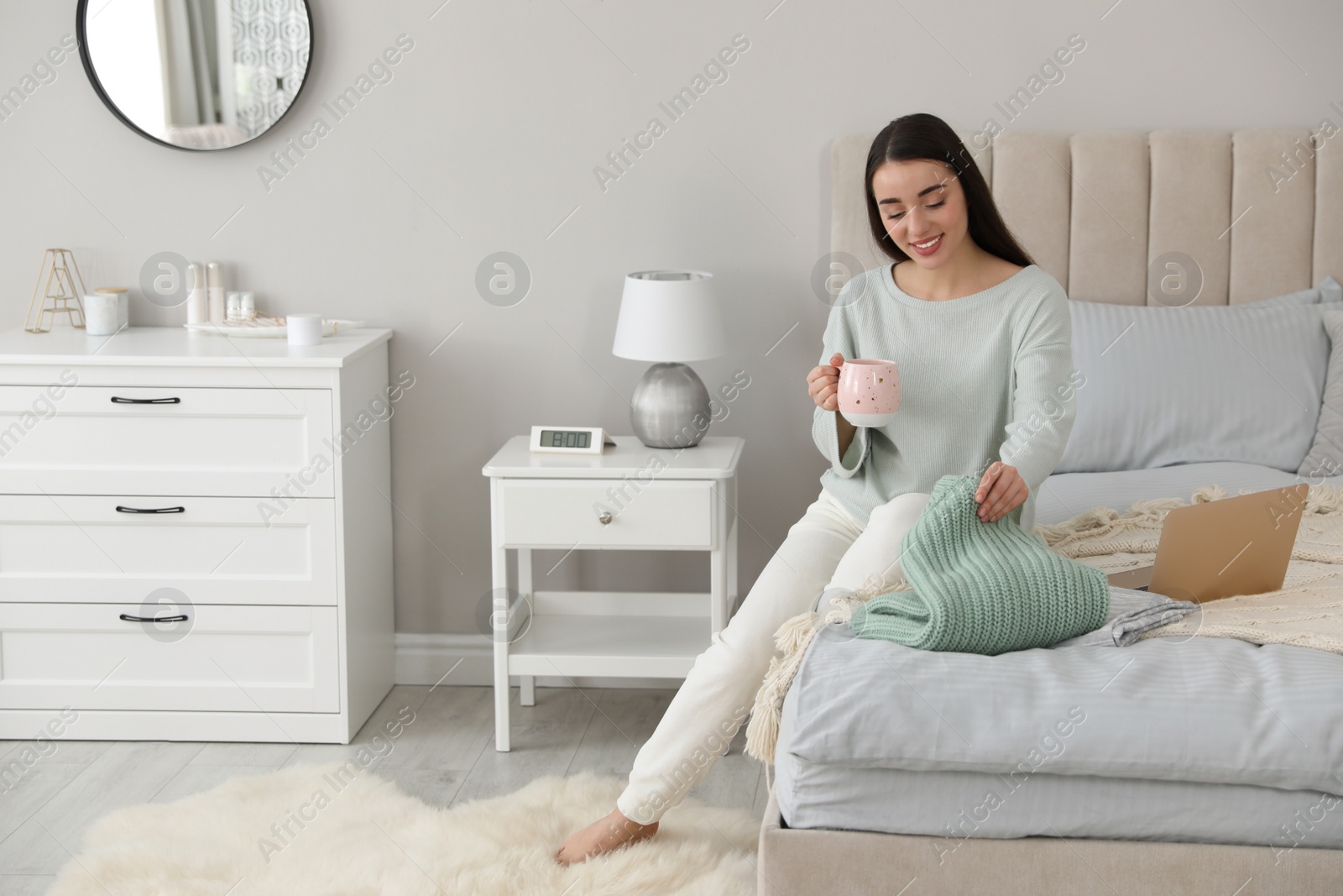 Photo of Young woman choosing clothes for work day at home. Morning routine