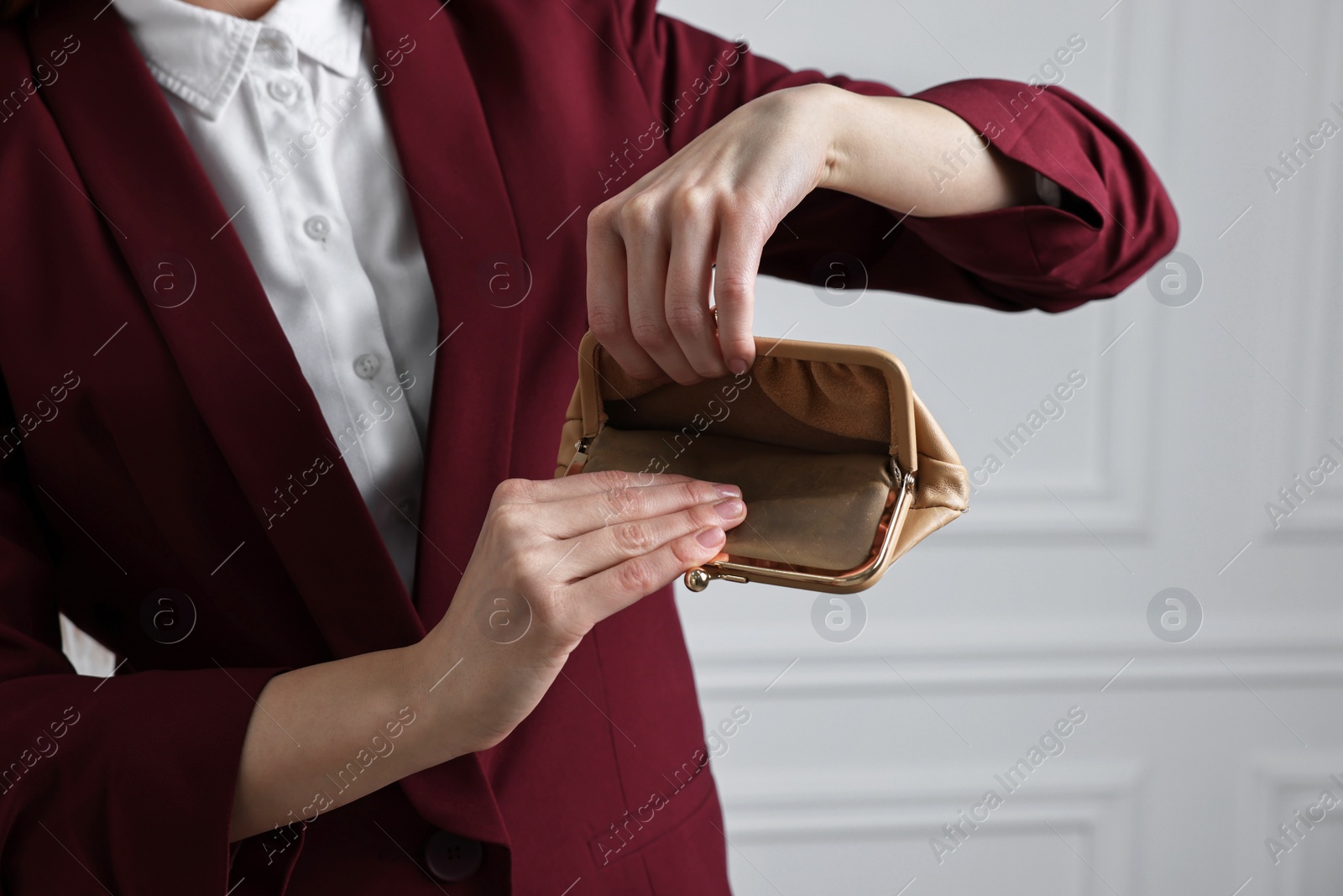 Photo of Woman with empty wallet near white wall, closeup