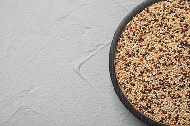 Photo of Plate with mixed quinoa seeds and space for text on grey background, top view