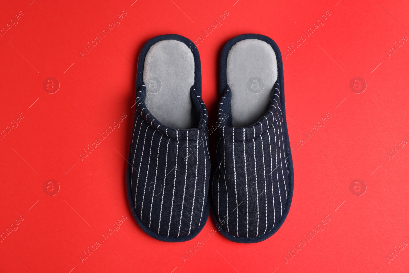 Photo of Pair of stylish slippers on red background, top view