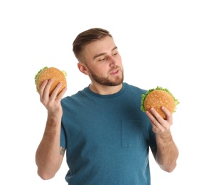 Young man with tasty burgers on white background