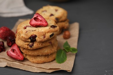 Photo of Cookies with freeze dried fruits, mint and nuts on grey table, closeup. Space for text