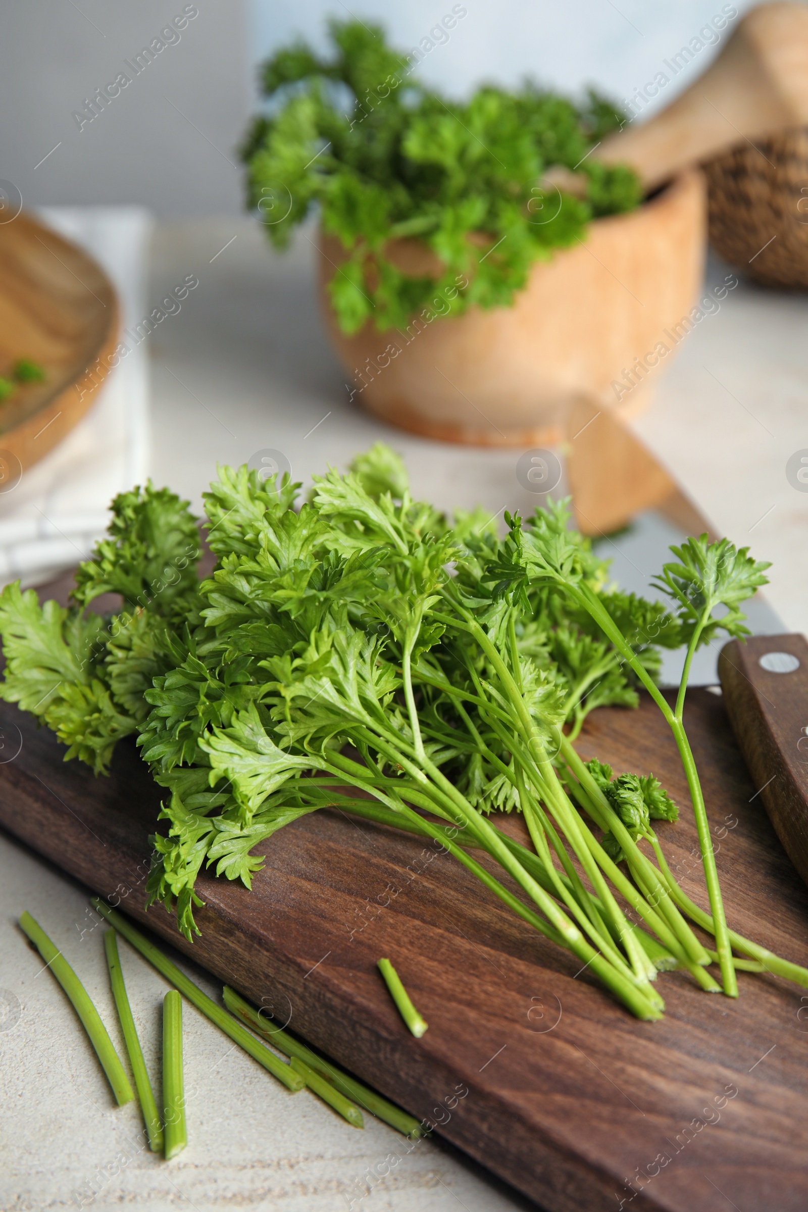 Photo of Wooden board with fresh green parsley on table