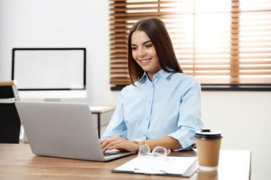 Young woman using video chat on laptop in home office