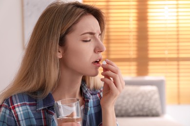 Photo of Upset young woman taking abortion pill at home