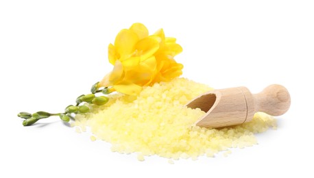 Photo of Yellow sea salt, flowers and scoop isolated on white