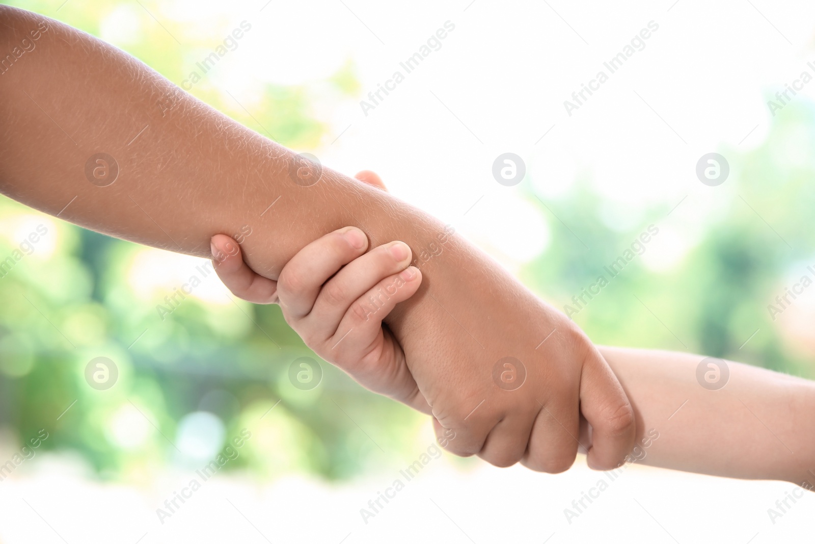 Photo of Children holding hands on blurred background, closeup. Unity concept