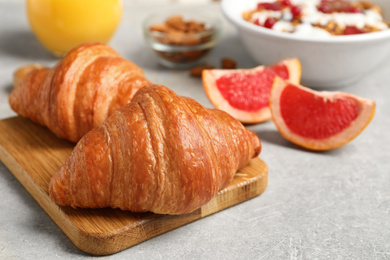 Photo of Tasty fresh croissants on light grey table. Healthy breakfast