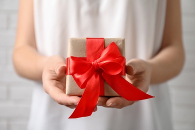 Photo of Woman holding beautiful gift box, closeup