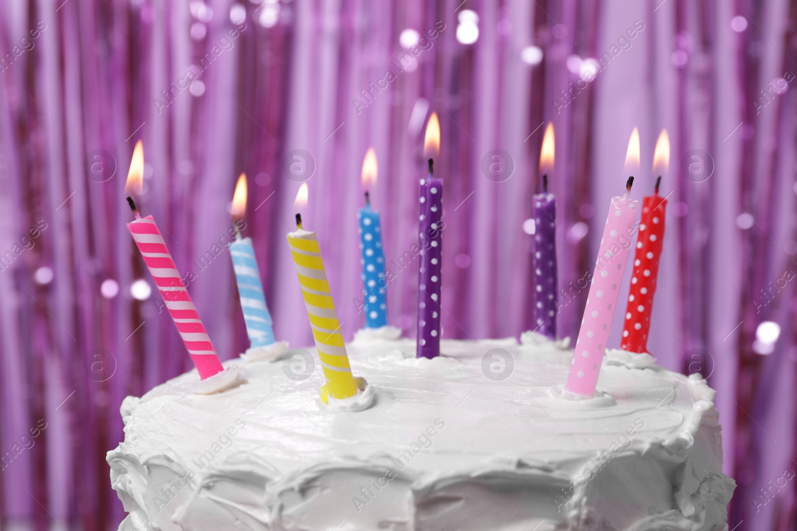 Photo of Delicious cake with cream and burning candles on purple background, closeup