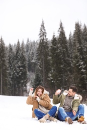 Photo of Couple spending time outdoors on snowy day, space for text. Winter vacation