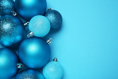 Christmas balls on light blue background, top view. Space for text