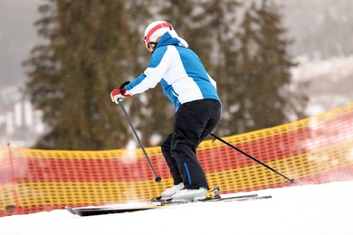 Photo of Skier on slope at resort. Winter vacation