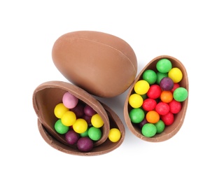 Photo of Tasty chocolate eggs with colorful candies on white background, top view