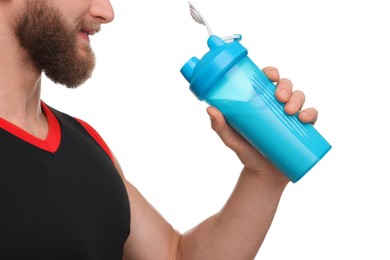 Photo of Young man with muscular body holding shaker of protein on white background, closeup