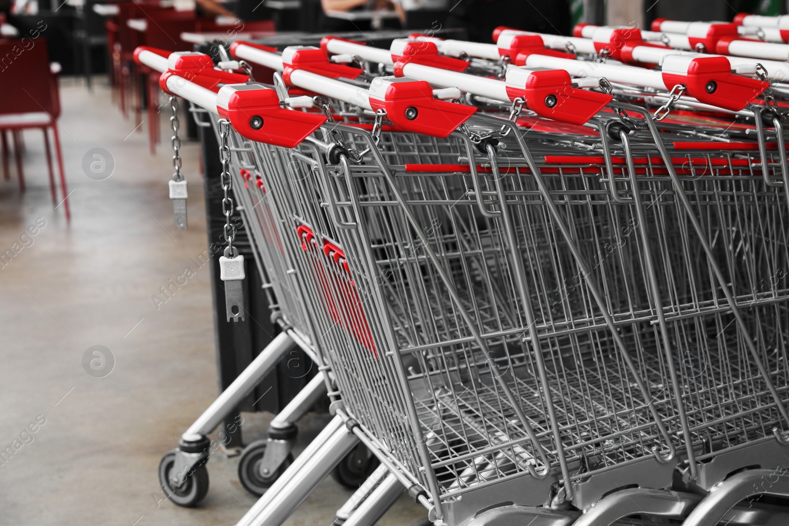 Photo of Many empty metal shopping carts near supermarket outdoors