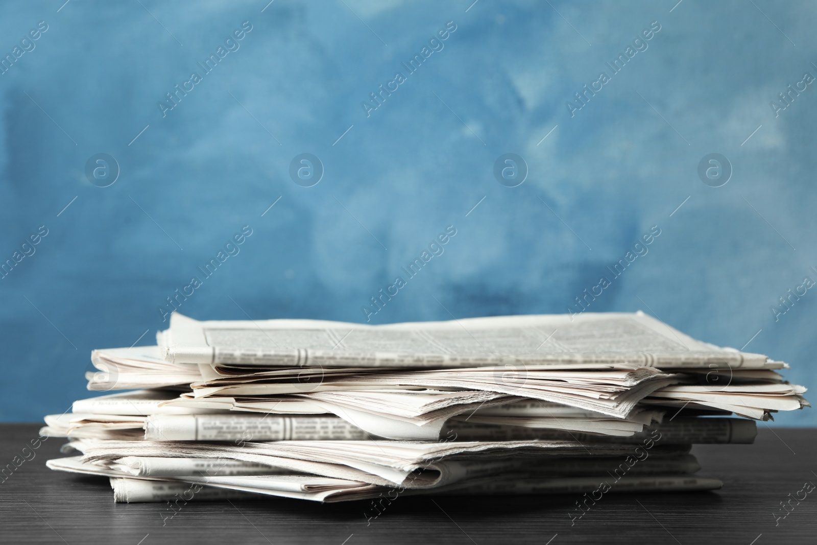 Photo of Pile of newspapers on blue background, space for text. Journalist's work