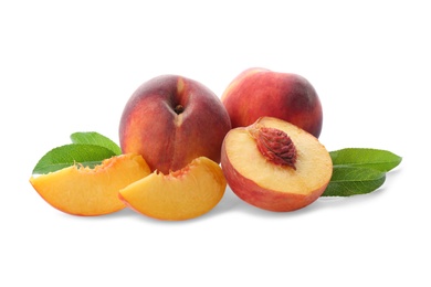 Whole and cut ripe peaches with leaves isolated on white