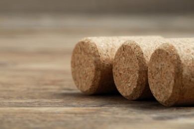 Photo of Corks of wine bottles on wooden table, closeup. Space for text