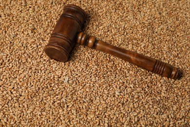Photo of Wooden gavel on wheat grains, above view. Agricultural deal