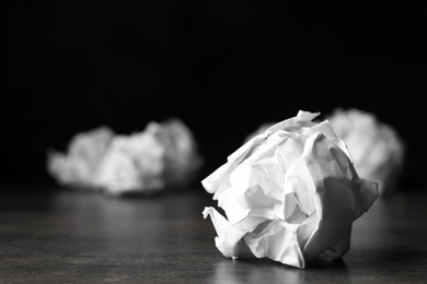 Photo of Ball of crumpled paper on grey table, space for text
