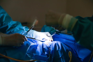 Photo of Professional doctors performing operation in surgery room, closeup